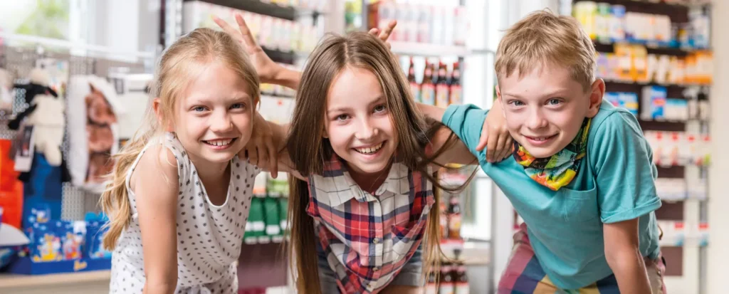 Drei lachende Kinder in der Apotheke