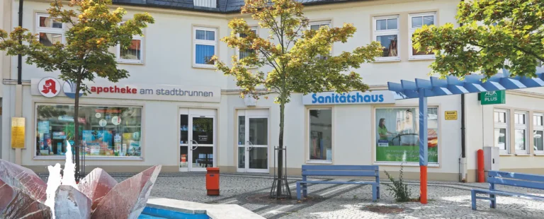 Außenansicht der Apotheke am Stadtbrunnen mit dem Sanitätshaus, davor der Stadtbrunnen